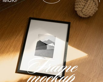 May include: A black framed art print mockup featuring a monochrome mountain scene. The words "Frame mockup" are displayed in a decorative font. The text "compatible with Photoshop, Photopea & Affinity" is also visible.