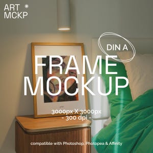 May include: A framed art print mockup with the text "FRAME MOCKUP" in large white letters. The artwork features a portrait with colorful brushstrokes. The frame is on a wooden nightstand next to a bed with green bedding.