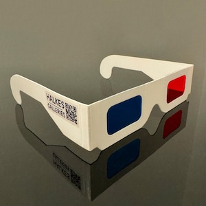 May include: White cardboard 3D glasses with blue and red lenses. The glasses have the text "HALKES GALLERIES" and a QR code printed on the side.