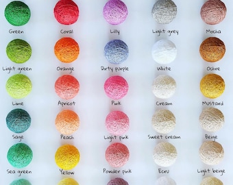 May include: A color palette chart featuring fifty spherical cotton ball lights arranged in five columns. Each ball is labeled with its specific color name, including shades like khaki, amaranth, blackberry, black, chocolate, green, coral, and azure.