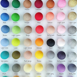 Könnte beinhalten: Eine Farbpalette von Baumwollkugelleuchten in verschiedenen Farben, darunter Dunkeldenim, Khaki, Braun, Burgunderrot und mehr. Das Bild zeigt eine große Auswahl an Farben, von dunkel bis hell, wobei jede Farbe beschriftet ist. Der Text unten lautet "Cotton Ball Lights color palette: Classic Collection".