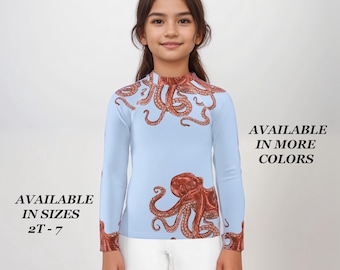 May include: A light blue long-sleeved shirt with an octopus print. The octopus is red and brown and has a detailed design. The shirt is available in sizes 2T-7 and in more colors.