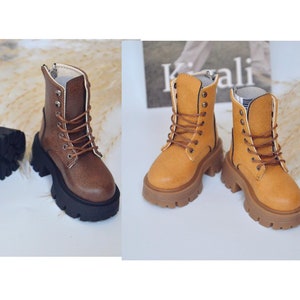 May include: Two pairs of brown and tan leather ankle boots with laces and a zipper. The boots have a chunky platform sole.