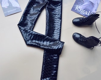 May include: Black faux leather leggings with a snakeskin pattern.