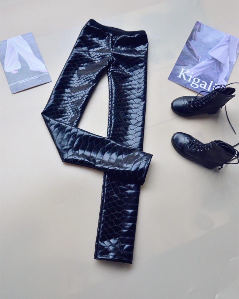 May include: Black faux leather leggings with a snakeskin pattern.