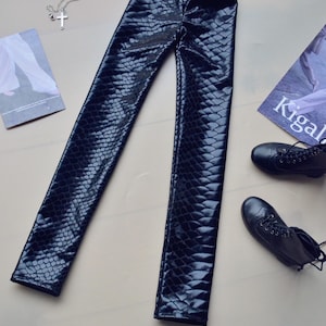May include: Black faux leather leggings with a snakeskin pattern.