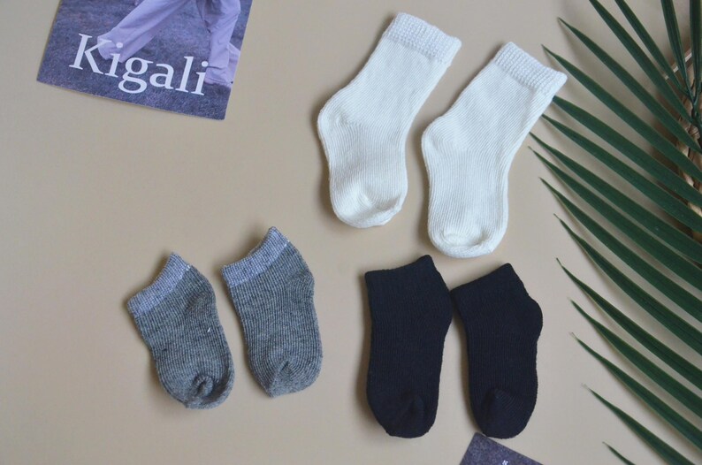 May include: Six pairs of socks in three different colours: white, grey, and black. The socks are all ankle-length and have a ribbed texture.