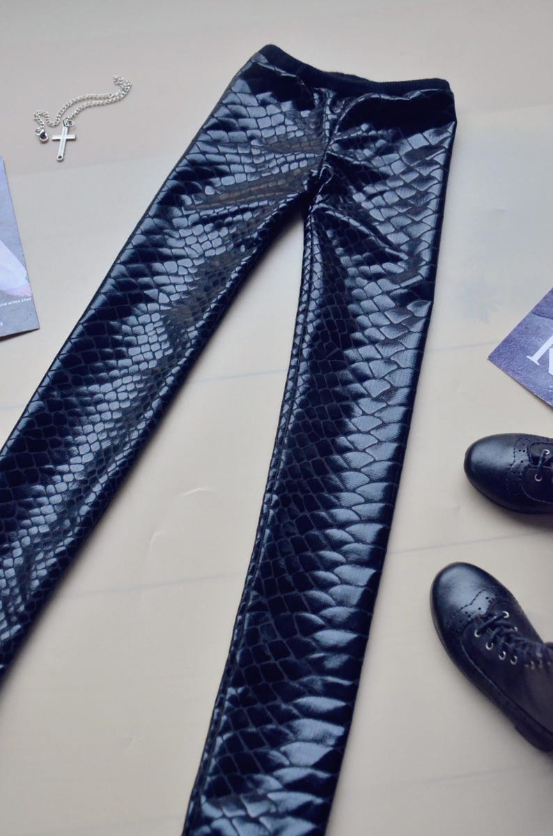 May include: Black faux leather leggings with a snakeskin pattern.