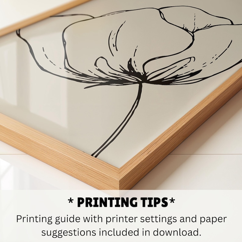 May include: A framed art print featuring a black and white floral illustration. The artwork is a minimalist line drawing of a flower against a cream-colored background, encased in a light brown wooden frame.