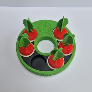 May include: A green and black dog puzzle toy featuring six red radish-shaped pieces, each with green leaves. The toy has a circular design with the text "P4P" in green. The radishes are set in a green circular frame.