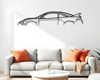 Puede incluir: Arte mural de metal negro que representa el contorno de un coche. La obra de arte está montada en una pared blanca sobre un sofá gris con cojines naranjas. También se ve una mesa de centro redonda blanca y una manta beige.