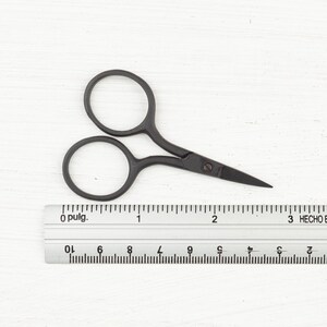 May include: Black metal scissors with a 2-inch blade length, shown next to a ruler.
