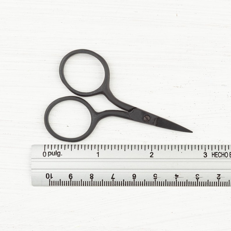 May include: Black metal scissors with a 2-inch blade length, shown next to a ruler.