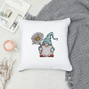 May include: White pillow with a colorful illustration of a gnome holding a daisy. The gnome is wearing a blue and white polka dot hat and red shoes.