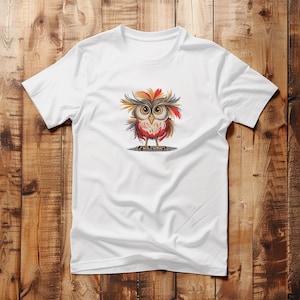 Pu&ograve; includere: Maglietta bianca con un'illustrazione di un gufo di cartone animato con piume rosse, gialle e marroni. Il gufo ha grandi occhi rotondi e un'espressione sorpresa.