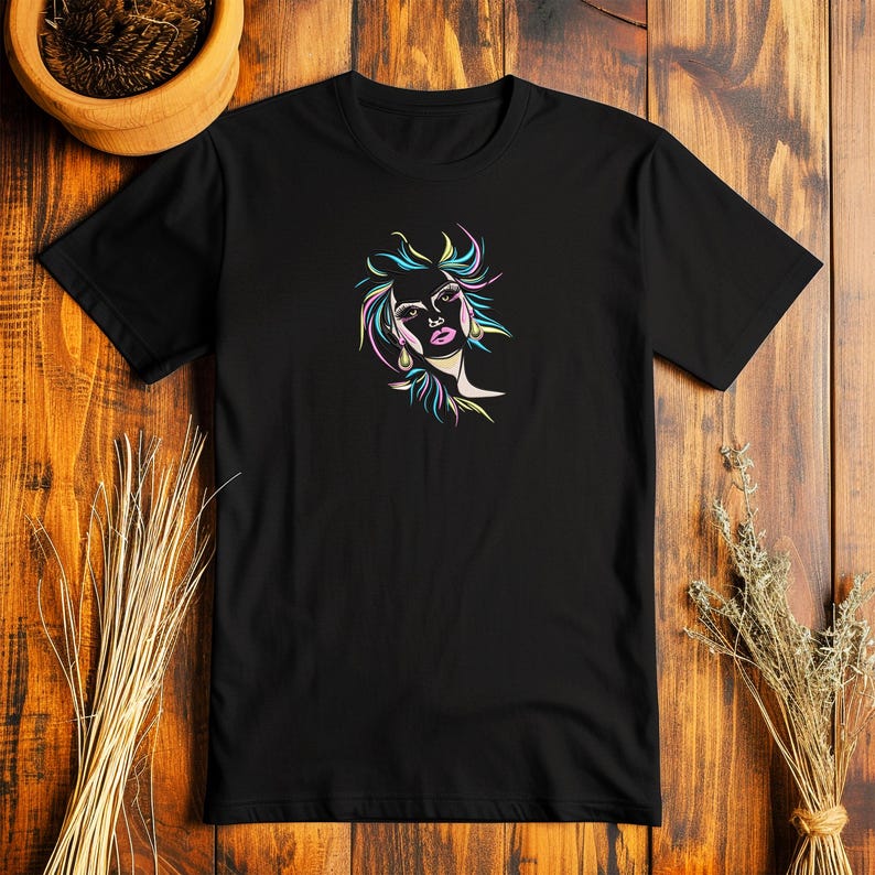 Puede incluir: Camiseta negra con un dise&ntilde;o de arte de l&iacute;nea de colores de la cara de una mujer.