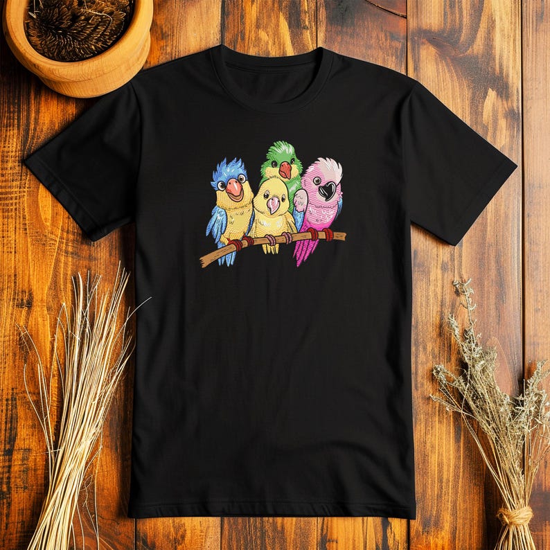 Peut inclure: T-shirt noir avec un motif de quatre perroquets color&eacute;s perch&eacute;s sur une branche. Les perroquets sont vert, bleu, jaune et rose.