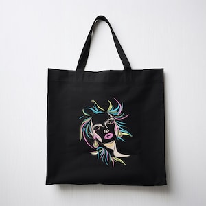 Puede incluir: Bolsa de tela negra con un dibujo de l&iacute;nea de color de la cara de una mujer en la parte delantera.