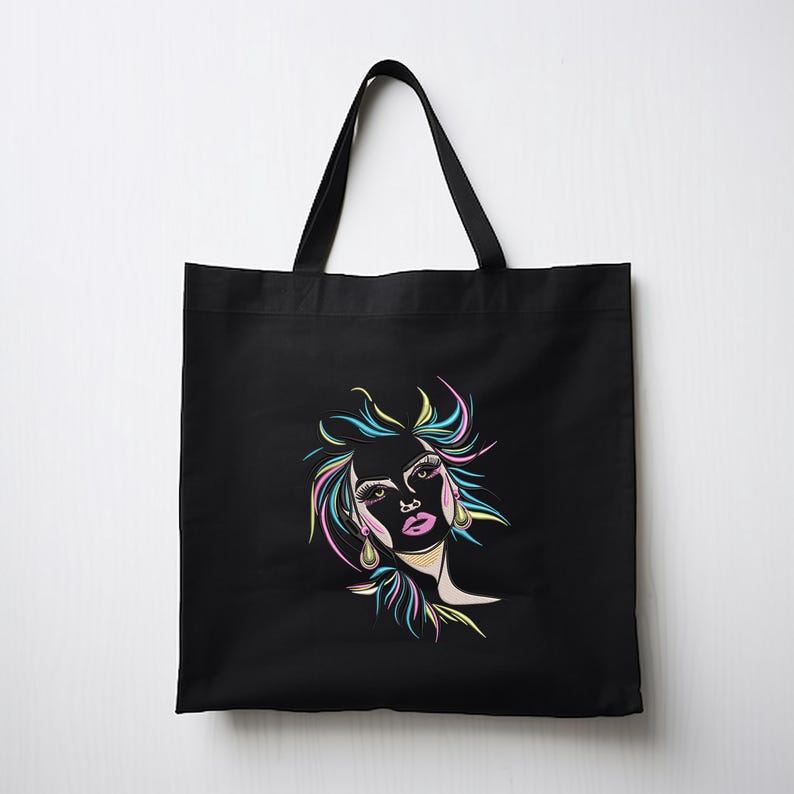 Puede incluir: Bolsa de tela negra con un dibujo de l&iacute;nea de color de la cara de una mujer en la parte delantera.