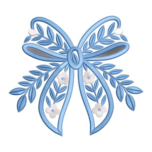 May include: A light blue bow design with embroidered details. The bow features leaves and small white flowers, with a central oval shape. The design is suitable for embroidery projects, crafts, or decorative applications.