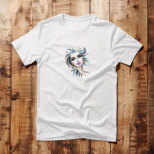 Puede incluir: Camiseta blanca con una ilustraci&oacute;n colorida de la cara de una mujer con labios rosas y ojos azules.