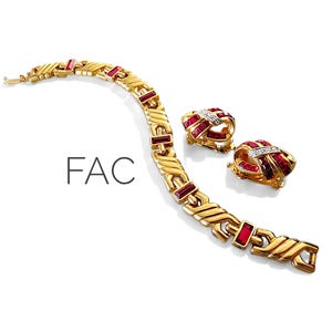 May include: A gold bracelet and earrings set with red and clear stones. The bracelet has a geometric design and the earrings are shaped like a knot.