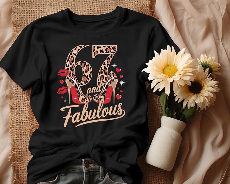 May include: Black t-shirt with a leopard print number 67 and the words "and fabulous" printed on it. The number 67 is decorated with two leopard print high heels.