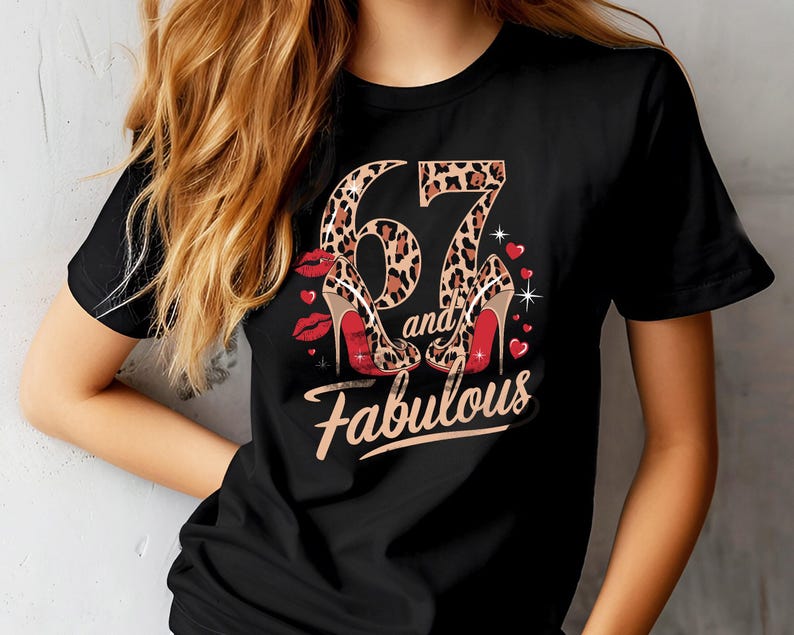 May include: Black t-shirt with a leopard print design featuring the number 67 and the words "and fabulous" in gold lettering. Two red high heels are shown on either side of the number.