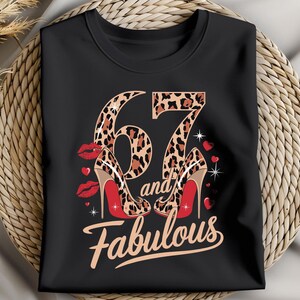 May include: Black t-shirt with a leopard print number 67 and the words "and fabulous" in white. The number 67 is surrounded by red lips and red high heels.