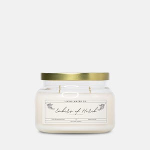 Peut inclure: Une bougie en verre transparent dans un pot avec un couvercle doré. L'étiquette indique "Living Water Co. Embers of Herbs Soy Wax Candle Made in the USA".