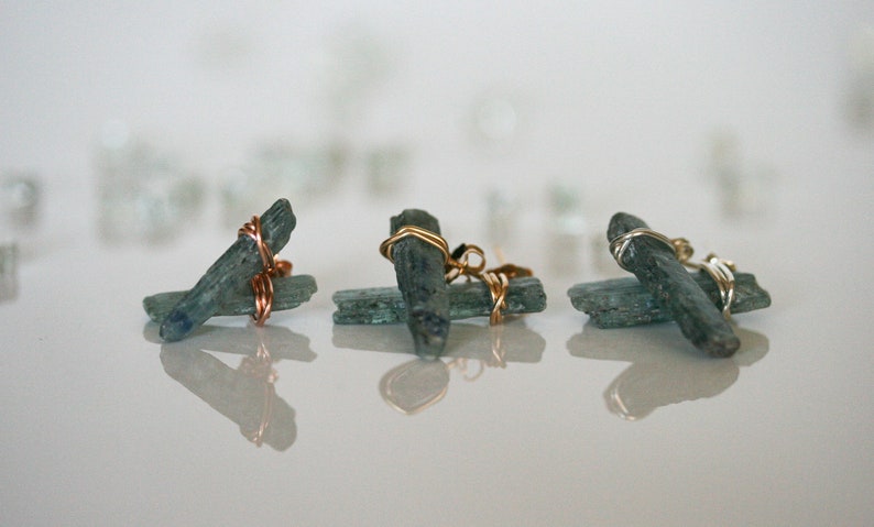 May include: Three pairs of earrings featuring blue kyanite crystals wrapped in copper and gold wire.