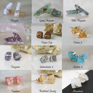 May include: Twelve pairs of earrings featuring various gemstones wrapped in gold or silver wire. The gemstones include kunzite, green kyanite, blue kyanite, amethyst pointe, tiger's eye, citrine, tanzanite, labradorite, apatite, sunstone, rutilated quartz, and moonstone.