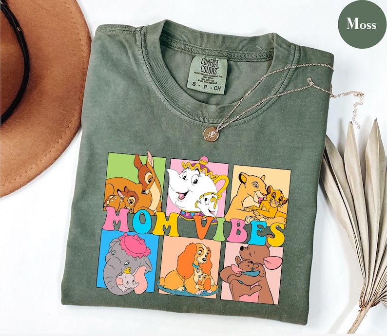 May include: A green t-shirt with a graphic of Disney characters and the text "MOM VIBES". The characters include Bambi, Lady and the Tramp, Dumbo, and Simba.