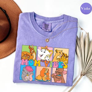 May include: Purple t-shirt with a graphic of Disney characters and the text "Mom Vibes".