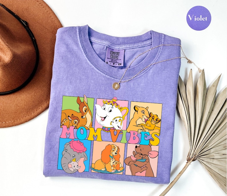May include: Purple t-shirt with a graphic of Disney characters and the text "Mom Vibes".
