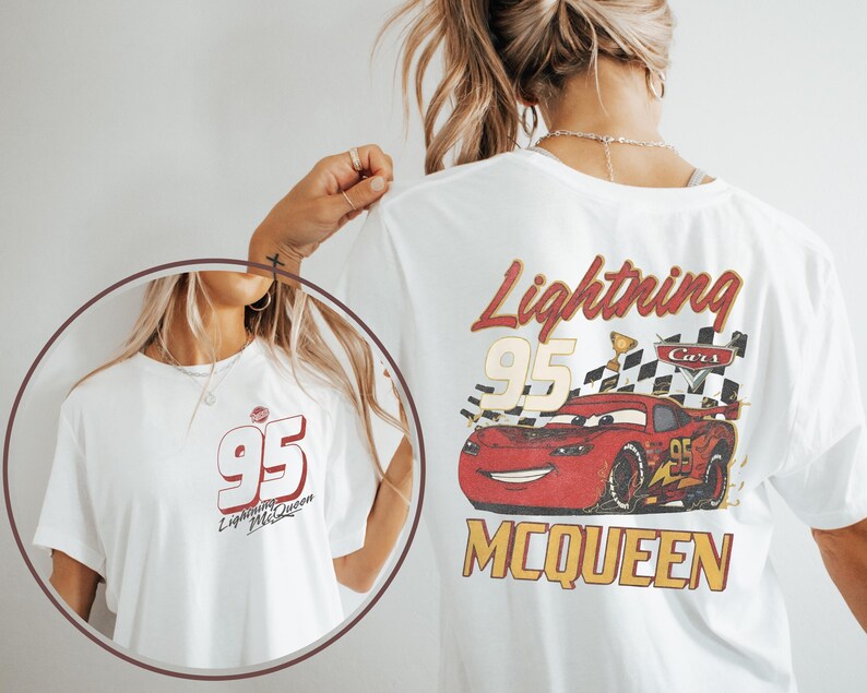 May include: A white t-shirt featuring a graphic of the red race car Lightning McQueen from the film Cars. The back design includes the number 95, a chequered flag, and the text Lightning McQueen. The front chest area displays the number 95.