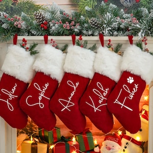 May include: Five red Christmas stockings with white faux fur trim hanging on a fireplace mantel. Each stocking is personalized with a name in white script:  "Jillian", "Sophia", "Amanda", "Kailah", and "Fisher".