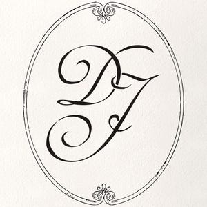 Op de afbeelding: Een ovaal ontwerp met de verweven letters "DJ" in een sierlijk, vloeiend schrift. De zwarte letters staan tegen een crèmekleurige achtergrond, omlijst door een dunne, decoratieve rand met bloemmotieven aan de boven- en onderkant.