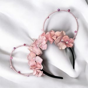 May include: Pink flower headband with a black headband and pink beads.