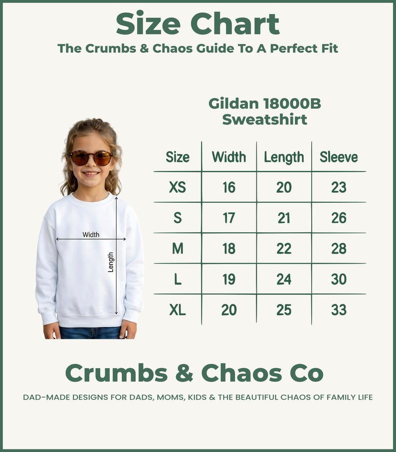 Puede incluir: Una sudadera blanca Gildan 18000B con una tabla de tallas. La tabla muestra medidas para las tallas XS a XL, incluyendo ancho, largo y largo de manga en cent&iacute;metros. El texto "Crumbs & Chaos Co" est&aacute; en la parte inferior.