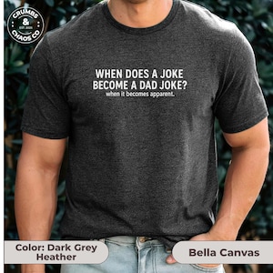 May include: Dark grey heather t-shirt with the text "WHEN DOES A JOKE BECOME A DAD JOKE? when it becomes apparent." The shirt is made by Bella Canvas. The Crumbs & Chaos Co. logo is in the upper left corner.