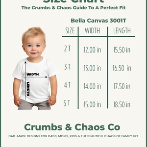 Puede incluir: Tabla de tallas de camisetas blancas para Bella Canvas 3001T, con medidas en cent&iacute;metros. La tabla incluye tallas de 2T a 5T, con un ancho que va de 30,48 cm a 38,10 cm y una longitud de 39,37 cm a 46,99 cm. Tambi&eacute;n se ve el texto "Crumbs & Chaos Co".