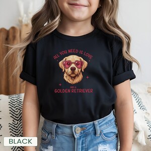Puede incluir: Camiseta negra con un Golden Retriever con gafas de sol en forma de coraz&oacute;n. El texto dice "ALL YOU NEED IS LOVE AND A GOLDEN RETRIEVER" en rojo. La palabra "BLACK" est&aacute; en la parte inferior.