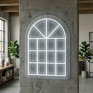 Op de afbeelding: Een boogvormige neonlamp in de vorm van een raam met een helder wit oplichtend frame. Het ontwerp bevat een centrale verticale balk en horizontale dwarsbalken die de binnenkant verdelen in twaalf rechthoekige panelen en twee driehoekige bovensecties.