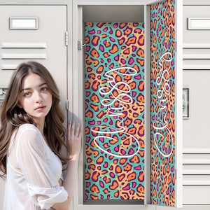 May include: A metal locker with an open door featuring a vibrant leopard print pattern in shades of teal, orange, and magenta. The interior back panel and the inside of the door display the white cursive text Crissy written in a flowing script.