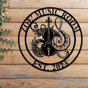 May include: Black metal wall art with the text "JOE'S MUSIC ROOM EST. 2023" in a circular design. The design features a violin, musical notes, and a piano keyboard.