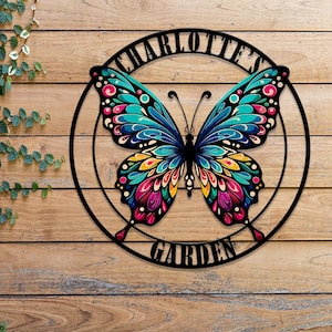 May include: A black metal circle with the words "Charlotte's Garden" around the edge. A colorful butterfly with blue, green, pink, and yellow wings is in the center of the circle.