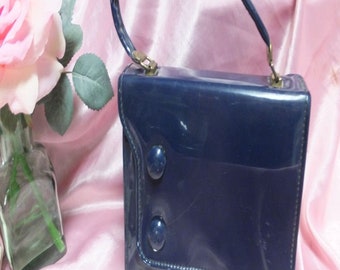 Bolso tipo pastillero de charol azul marino de los años 60, con base con patas, dos compartimentos laterales, bolso pequeño o de mano.