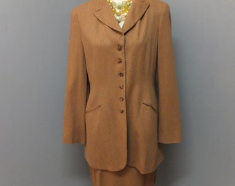 May include: A brown skirt suit with a long-sleeved jacket and a skirt. The jacket has a button-up front and a collar. The skirt is knee-length.