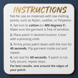 May include: A white square card with rounded corners, featuring gold text that reads "INSTRUCTIONS." The card provides detailed steps for applying a patch with an iron, including temperature and time guidelines. The background is a dark blue fabric.